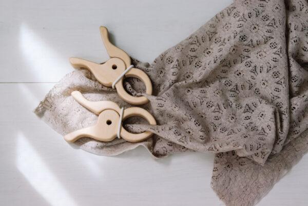 Houten reuze speelknijpers houden een grijze speeldoek vast