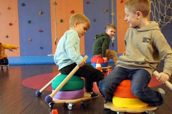 Kinderen gebruiken houten Pedalo-peddels op rolplanken