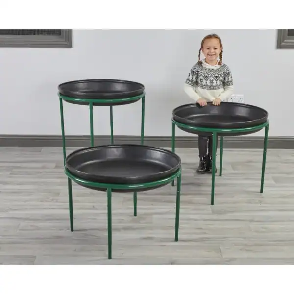 Kind achter zwarte ronde Deep Spot Trays op groene standaards