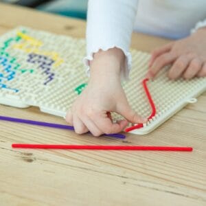 Kind legt een rood siliconen koord in het TickiT SiliShapes doolhof