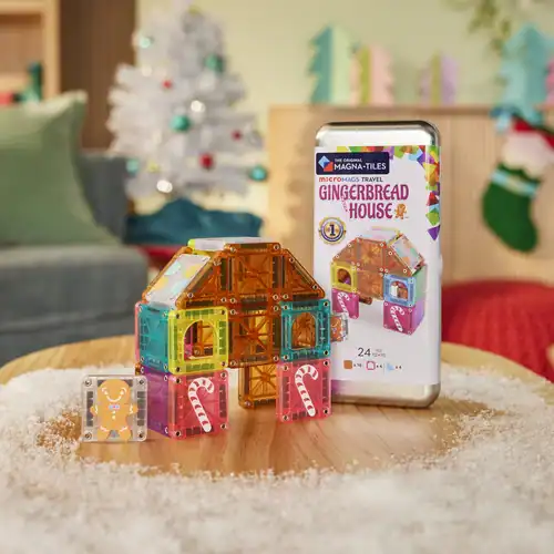 MAGNA-TILES Gingerbread House – speelopstelling Peperkoekhuisje gebouwd met MAGNA-TILES microMAGS Gingerbread House naast het reisblik