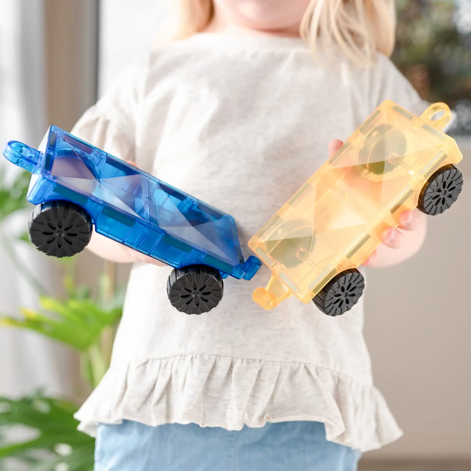 Spelen met Connetix auto’s Kind speelt met een voertuig van Connetix tegels en een autobase