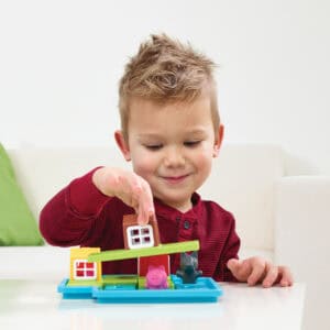 Kind plaatst een huisje op het spelbord van SmartGames Drie Kleine Biggetjes Deluxe