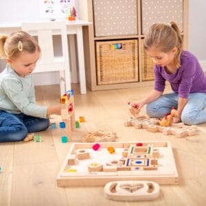 Twee kinderen spelen met Tickit houten bouwblokken en edelstenen