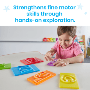 Kind volgt met een knikker de paarse MarbleTracers-letterbaan, met andere kleine letters op tafel