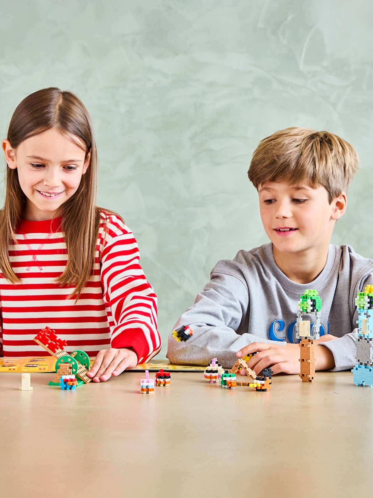 Twee kinderen spelen met de Plus-Plus Angry Birds Slingshot Smash-bouwset Twee kinderen spelen met de Plus-Plus Angry Birds Slingshot Smash-bouwset